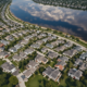 Aerial view of suburban homes with for sale signs showing